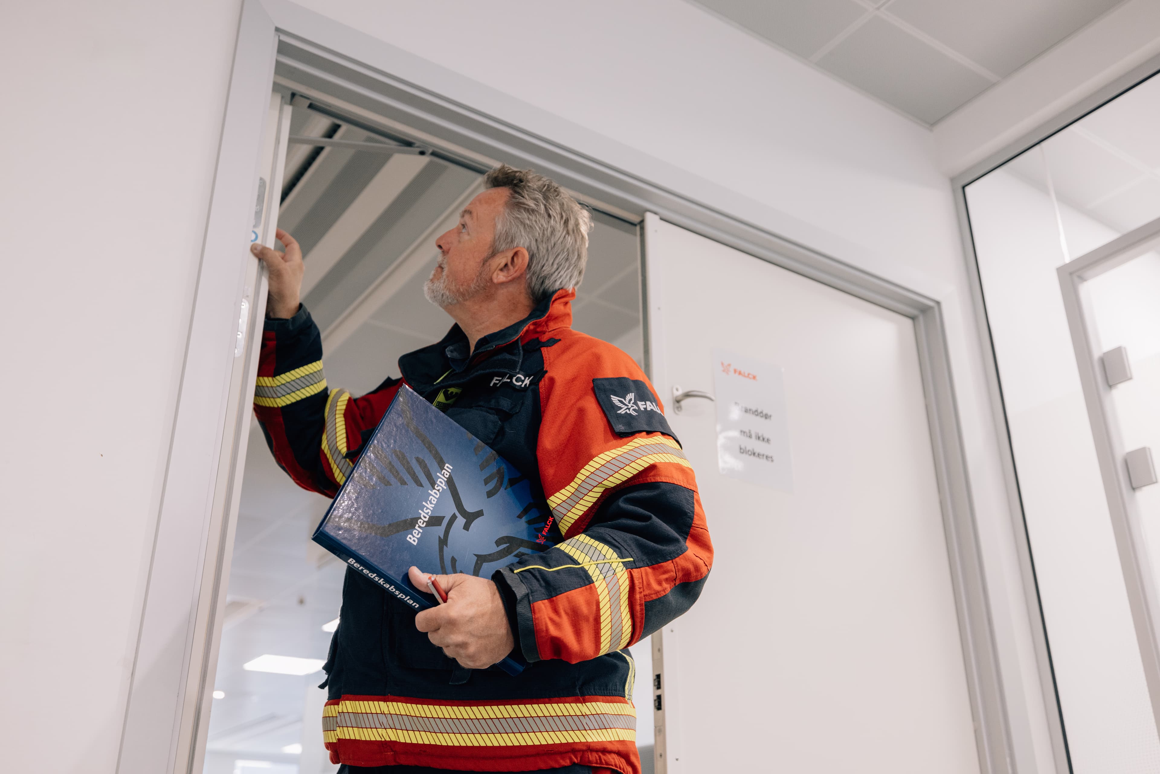 Falcks ekspert tjekker brandsikkerhed på en åben dør