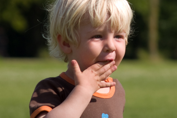 Lille dreng med fingre i munden